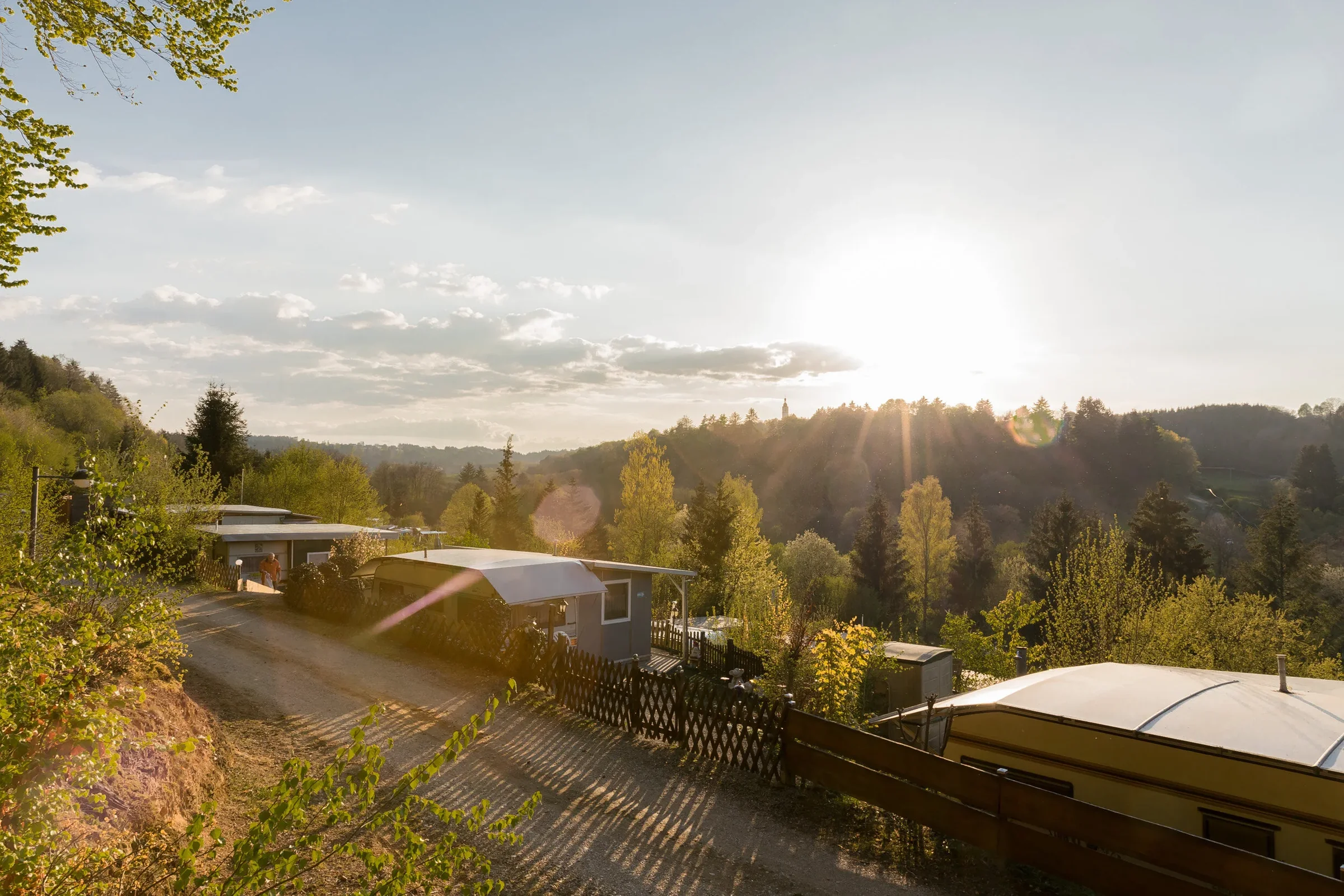 Sonnenstrahlen über den begrünten Dauerstellplätzen.