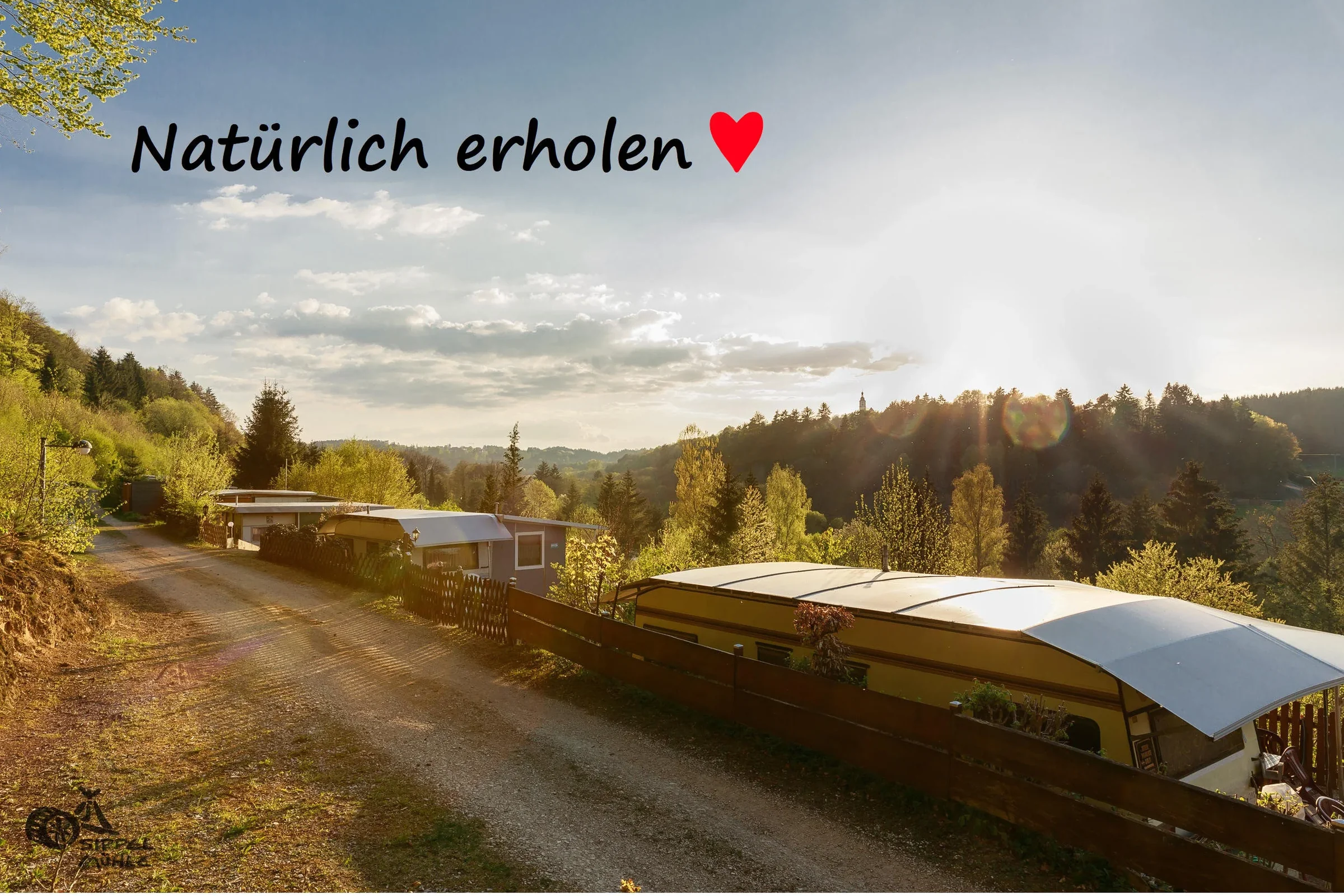 Blick über Dauerstellplätze mit dem Schriftzug: Natürlich erholen.