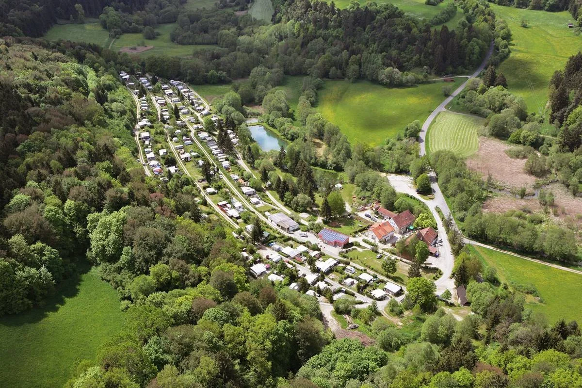 Luftbild des Campingplatzes und des Weiher mit Badestelles im Tal.