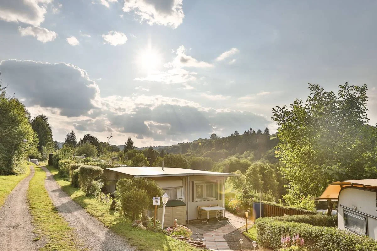 Sonniger Weg zwischen den Dauerstellplätzen mit Blick ins Tal.