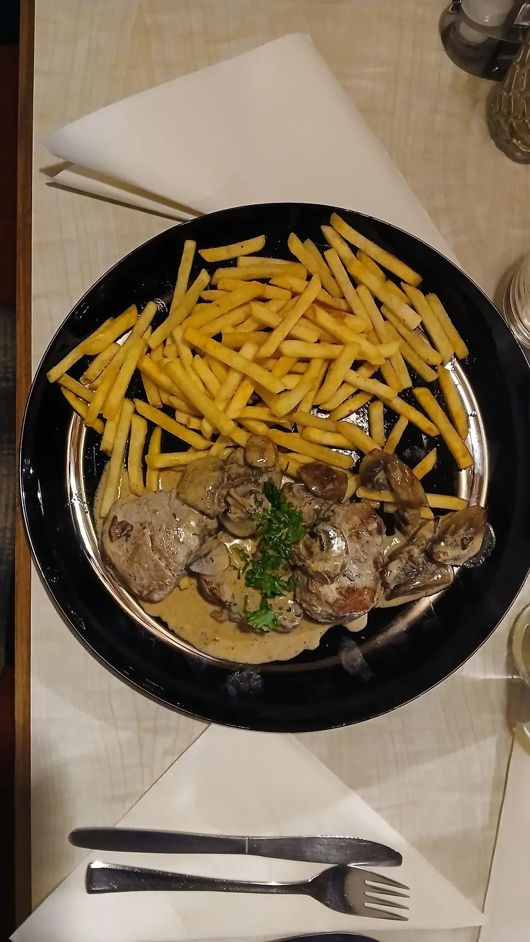 Teller mit Pommes und Fleischgericht.
