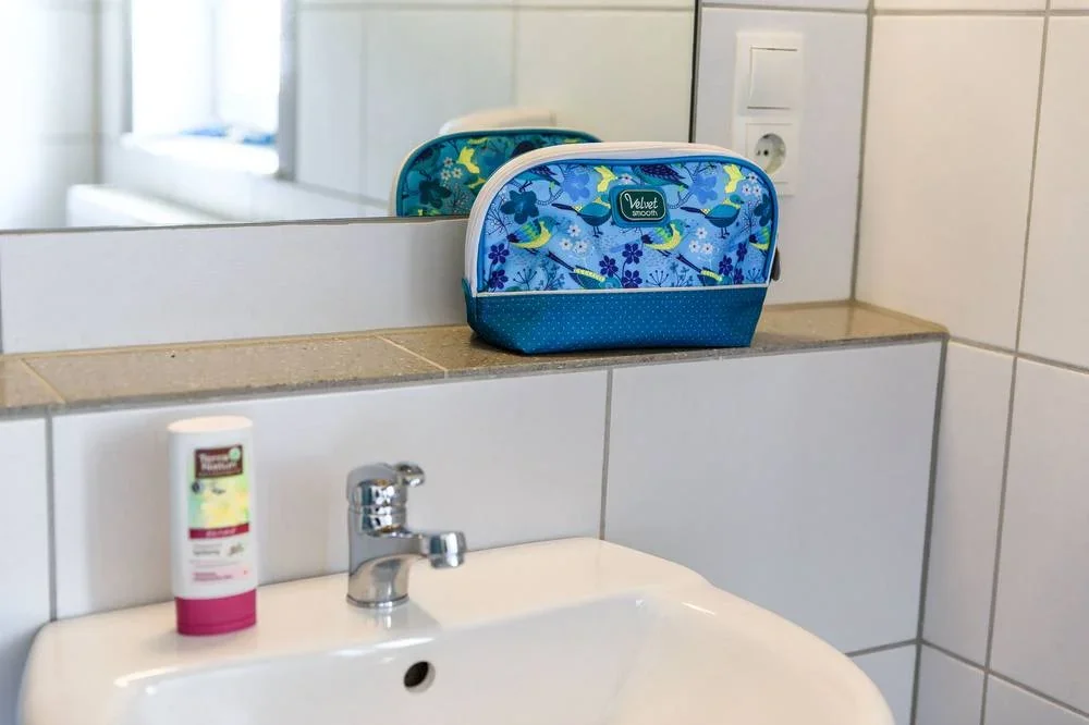 Waschbecken mit Spiegel und Ablage für die Kulturtasche.