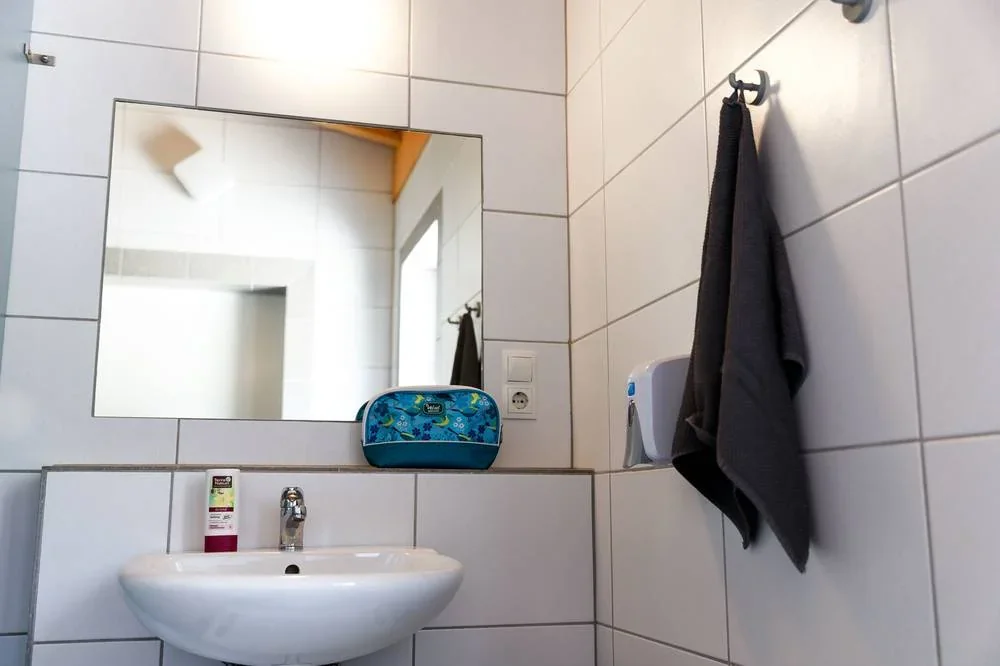 Heller Waschplatz mit Spiegel und Handtuchhaken.