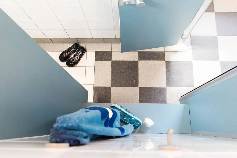 Ablage mit Handtuch und Umkleidebereich vor der Dusche.