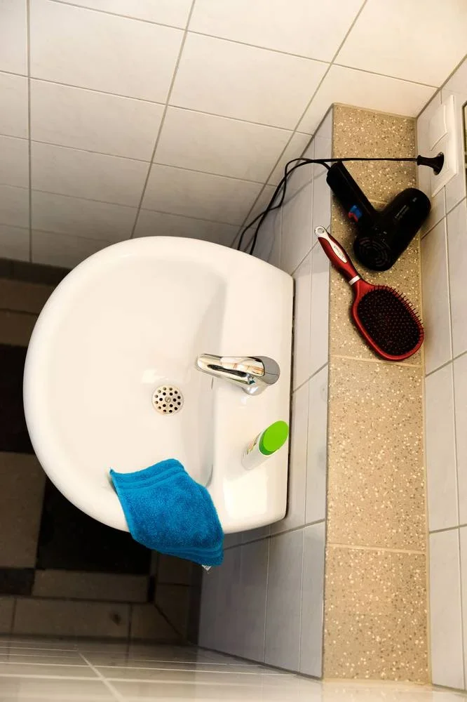 Waschbecken und Ablage in einer Einzelwaschkabine aus der Draufsicht.