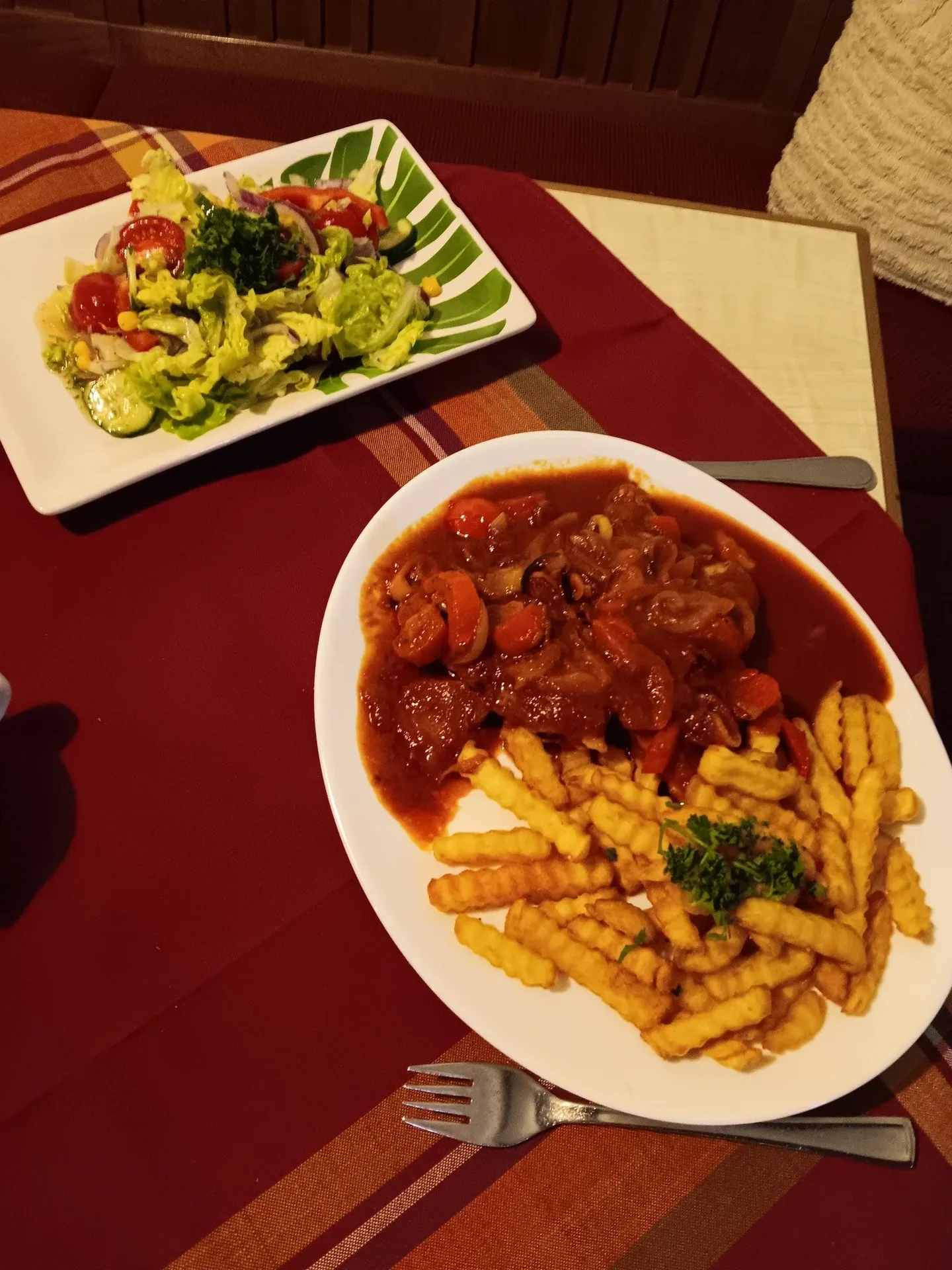 Teller mit Schnitzel ungarischer Art und Pommes.