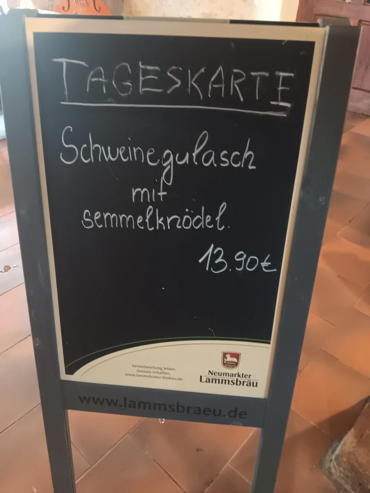 Tafel mit Tageskarte für Schweinegulasch und Semmelknödel.