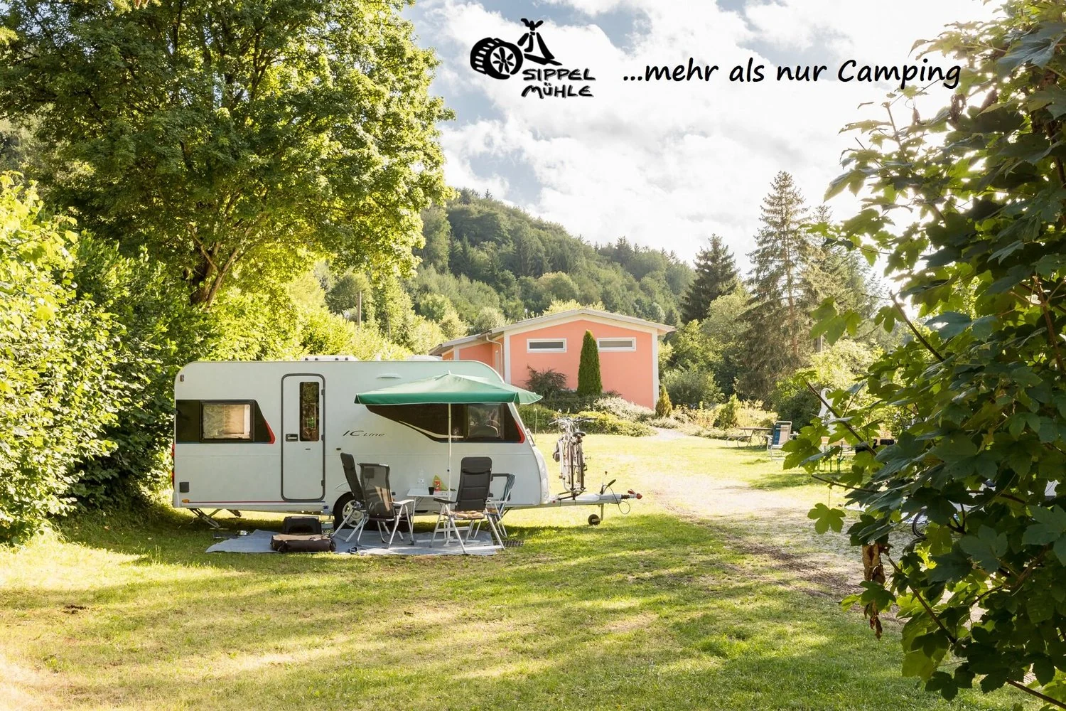 Wohnwagen mit Vorzelt auf dem begrünten Campingplatz.