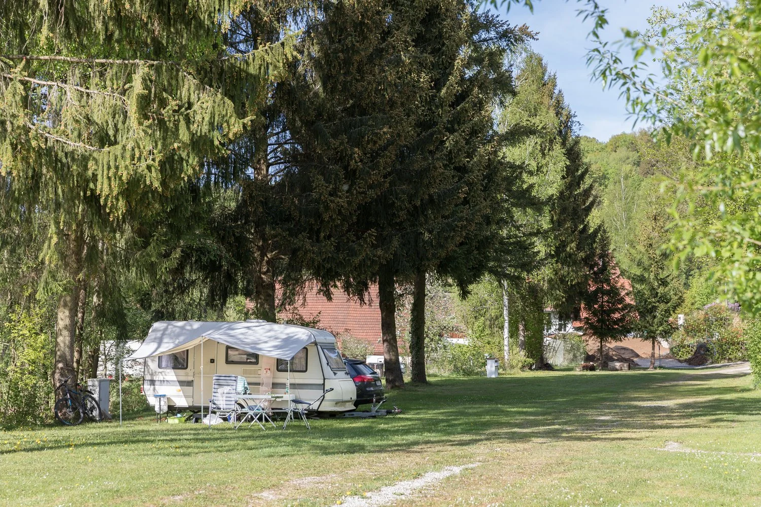 Wohnwagen im Schatten einer großen Weide.