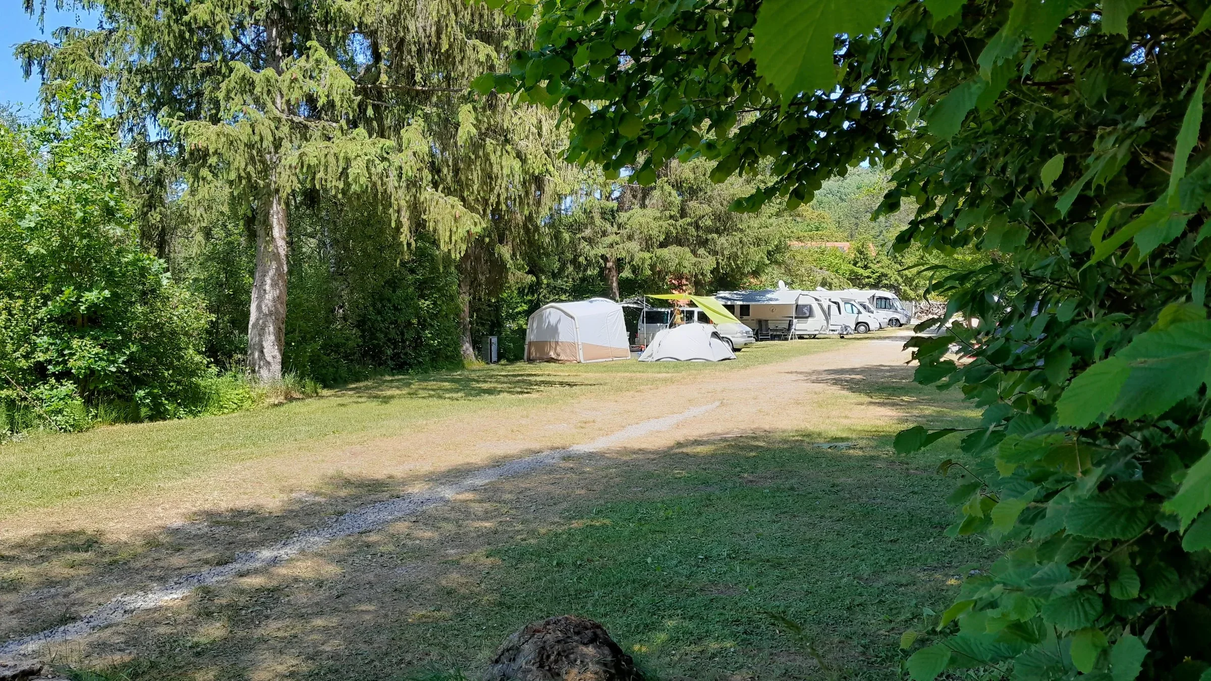 Weg zwischen begrünten Stellplätzen auf dem Campingplatz.
