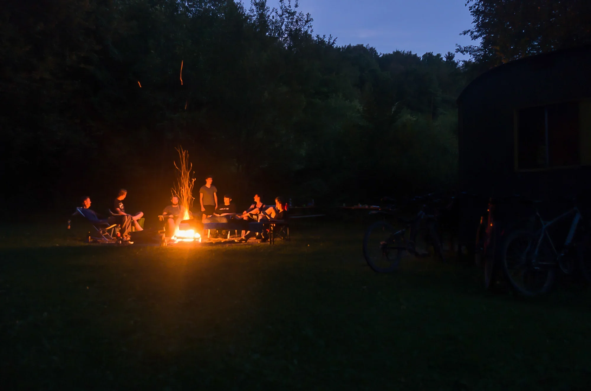 Lagerfeuer am Gruppenplatz Waldi in der Dämmerung.